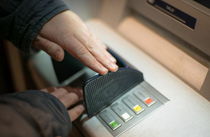 man carefully using an ATM